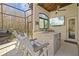 Outdoor kitchen featuring a built-in grill, stone countertop, TV, and bar seating at 5204 Avenue La Crosse, Lutz, FL 33558