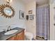 Cozy bathroom with blue and white patterned shower curtain, vanity, and sunburst mirror at 547 Suwanee Cir, Tampa, FL 33606