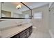 Traditional bathroom with a large mirror, decorative lighting, a solid surface countertop, and white tile at 547 Suwanee Cir, Tampa, FL 33606