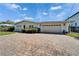 Home featuring a well-maintained lawn and a large two-car garage at 547 Suwanee Cir, Tampa, FL 33606
