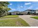 View of the house with front lawn and a brick driveway, set on a sunny day at 547 Suwanee Cir, Tampa, FL 33606