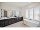 Bright bathroom featuring dual vanities, a freestanding tub, and a separate shower with natural light at 5932 Red Mangrove Ln, Bradenton, FL 34210