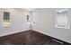 Bedroom with hardwood floors, white walls and base molding, and three windows with views of the neighborhood at 5932 Red Mangrove Ln, Bradenton, FL 34210