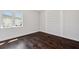 A bedroom with hardwood floors, white walls and base molding, a window, and built-in shelving at 5932 Red Mangrove Ln, Bradenton, FL 34210