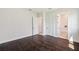 Spacious bedroom featuring hardwood floors, white walls, base molding, and doors to the bathroom at 5932 Red Mangrove Ln, Bradenton, FL 34210