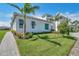 Charming single-story home featuring lush green lawn, tropical landscaping, and a paver walkway at 5932 Red Mangrove Ln, Bradenton, FL 34210