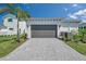 Beautiful home with a large gray garage door and a gray brick paver driveway at 5932 Red Mangrove Ln, Bradenton, FL 34210