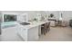 Modern kitchen featuring a large island with built in cooktop and breakfast bar, connecting to an outdoor pool area at 5932 Red Mangrove Ln, Bradenton, FL 34210