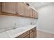 Bright laundry room with tile floors, gray cabinets, a white quartz countertop, and a sink at 5932 Red Mangrove Ln, Bradenton, FL 34210
