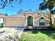 Charming single-story home with a well-manicured lawn, and attached two-car garage on a sunny day at 6004 Martinglade Pl, Lithia, FL 33547