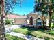 Charming single-story home with a well-manicured lawn, two-car garage and mature trees on a sunny day at 6004 Martinglade Pl, Lithia, FL 33547