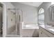 Bright bathroom with a glass-enclosed shower and a luxurious soaking tub, offering a spa-like experience at 6004 Martinglade Pl, Lithia, FL 33547