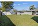 Large backyard with green grass, shade trees, and a partial fence at 8025 N Gomez Ave, Tampa, FL 33614