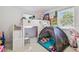 Fun ' bedroom featuring a loft bed with a play area and ample natural light at 8025 N Gomez Ave, Tampa, FL 33614