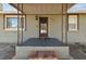 Inviting entryway featuring a covered porch with decorative iron posts and brick steps at 8025 N Gomez Ave, Tampa, FL 33614