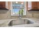 Close-up of a modern kitchen sink with granite countertops and a view of the neighborhood at 8025 N Gomez Ave, Tampa, FL 33614