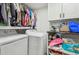 Well-organized laundry room with white cabinets, shelving, and modern washer and dryer at 8025 N Gomez Ave, Tampa, FL 33614