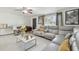 Modern living room with gray sectional sofa, large windows, and sleek decor, perfect for relaxing at 8025 N Gomez Ave, Tampa, FL 33614