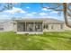 A covered lanai overlooks the spacious, beautifully landscaped backyard at 9402 Stonewall Ln, New Port Richey, FL 34655