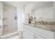 Bathroom featuring granite countertops, a tiled walk-in shower, and neutral paint at 9402 Stonewall Ln, New Port Richey, FL 34655