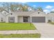 Charming single-story home with gray and white exterior paint, attached two-car garage, and well-maintained lawn at 9402 Stonewall Ln, New Port Richey, FL 34655