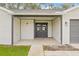 Charming front porch with double doors and stylish exterior lighting, set against a freshly painted brick facade at 9402 Stonewall Ln, New Port Richey, FL 34655
