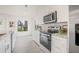 Kitchen featuring stainless steel appliances, marble backsplash, and bright natural light at 9402 Stonewall Ln, New Port Richey, FL 34655
