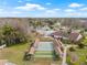 Aerial view of shuffleboard courts with covered seating and a nearby community pool with lake access at 9402 Stonewall Ln, New Port Richey, FL 34655
