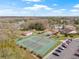 Aerial view of well maintained tennis courts and a parking area, surrounded by lush landscaping and residential homes at 9402 Stonewall Ln, New Port Richey, FL 34655