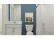 Modern bathroom featuring white subway tile, white vanity, and a stylish blue accent wall at 10212 Gentle Rain Dr, Land O Lakes, FL 34638
