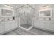 Elegant bathroom featuring a glass enclosed shower with marble surround and double sink vanities at 10800 Tarflower Dr # 202, Venice, FL 34293