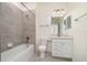 Clean bathroom featuring a shower and bath combo with gray tile and a white vanity and toilet at 10800 Tarflower Dr # 202, Venice, FL 34293