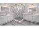Modern bathroom featuring a glass-enclosed shower with a white marble surround and dual vanities at 10800 Tarflower Dr # 202, Venice, FL 34293
