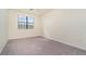 Well-lit bedroom featuring a large window, neutral walls and soft carpet at 10800 Tarflower Dr # 202, Venice, FL 34293