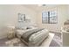 Bright bedroom featuring a large window, neutral walls, soft carpet, and a stylish, decorated queen bed at 10800 Tarflower Dr # 202, Venice, FL 34293