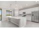 A modern kitchen featuring a large island, stainless steel appliances, and a window with natural light at 10800 Tarflower Dr # 202, Venice, FL 34293