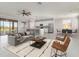 Spacious living room with gray sofa, leading to a modern open kitchen at 10800 Tarflower Dr # 202, Venice, FL 34293