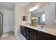 Well-lit bathroom featuring double sinks, a large mirror, and tile flooring at 11753 Sunburst Marble Rd, Riverview, FL 33579