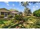 Lush backyard showcasing a screened-in pool, mature plants, and vibrant green grass at 1213 Halifax Ct, Tarpon Springs, FL 34688