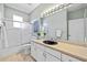 Bright bathroom with a shower over tub, a vanity with a black sink, and a large mirror at 1213 Halifax Ct, Tarpon Springs, FL 34688