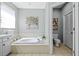 Bathroom with soaking tub, adjacent toilet and wall art at 1213 Halifax Ct, Tarpon Springs, FL 34688