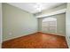 Inviting bedroom with rich hardwood floors, a ceiling fan, and a bright arched window at 1213 Halifax Ct, Tarpon Springs, FL 34688