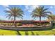 An entrance to a community with meticulously maintained landscaping and colorful flora at 1213 Halifax Ct, Tarpon Springs, FL 34688