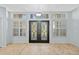 Inviting foyer featuring double front doors with decorative glass and tile flooring, bathed in natural light at 1213 Halifax Ct, Tarpon Springs, FL 34688