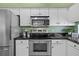 Updated kitchen with stainless steel appliances and plenty of counter space and white cabinets at 1213 Halifax Ct, Tarpon Springs, FL 34688