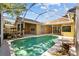 Screened-in pool with tile trim, flowers and a tranquil residential view at 1213 Halifax Ct, Tarpon Springs, FL 34688