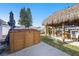 Charming backyard featuring a tiki hut with a grill and a wooden hot tub, ideal for relaxation and entertaining guests at 13429 Lisa Dr, Hudson, FL 34667