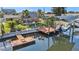 Backyard with boat dock, lift, tiki hut, outdoor furniture, and lush landscaping, overlooking the water at 13429 Lisa Dr, Hudson, FL 34667