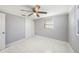 This bedroom has a ceiling fan, white-tile floors, base-molding, and two windows at 13429 Lisa Dr, Hudson, FL 34667