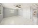 This bedroom has a ceiling fan, white-tile floors, base-molding, and one window at 13429 Lisa Dr, Hudson, FL 34667